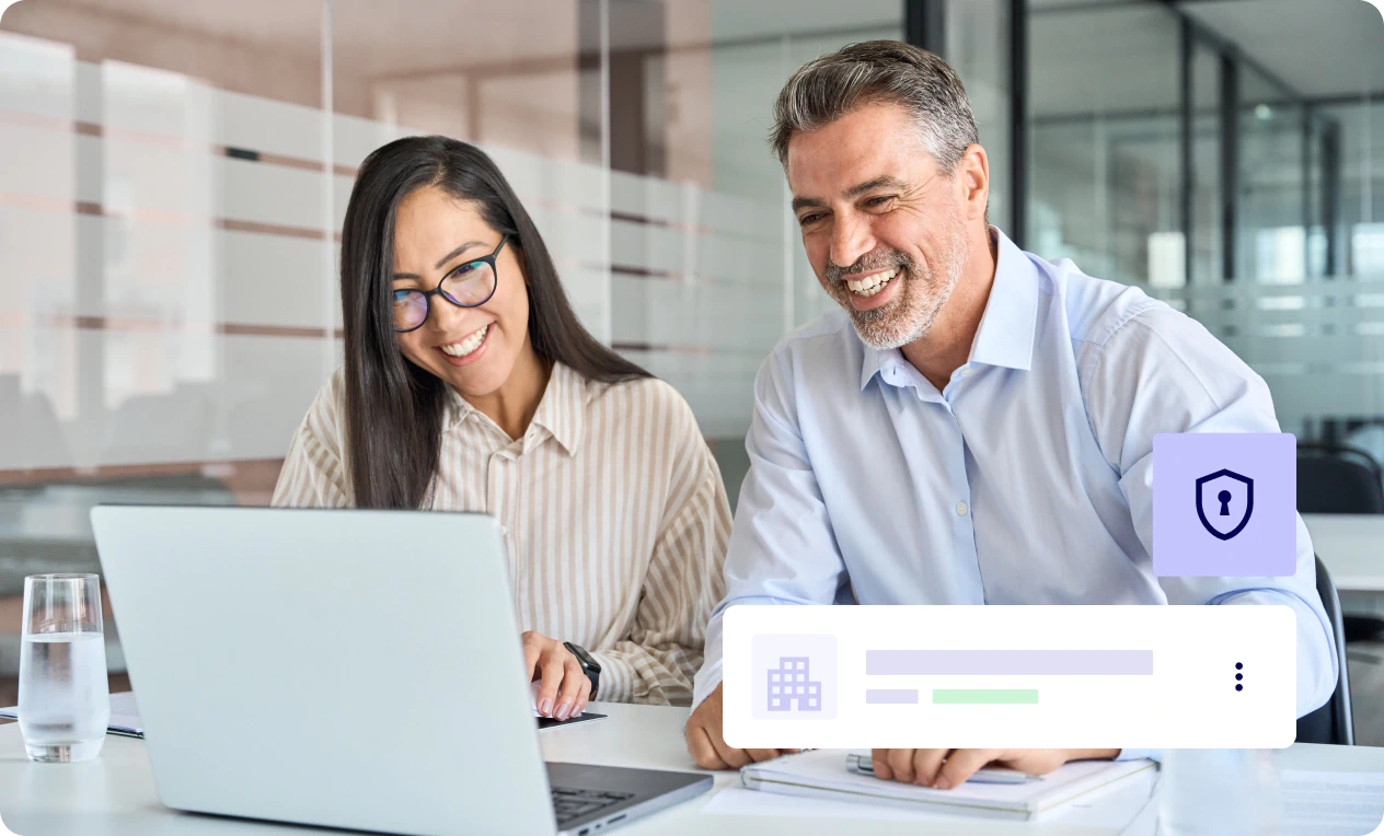 Two professionals working together on a laptop in an office.